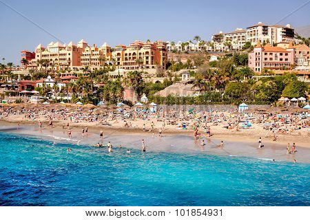 People Swimming And Sunbathing On The El Duque Beach