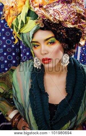 beauty bright woman with creative make up, many shawls on head like cubian, ethno look closeup