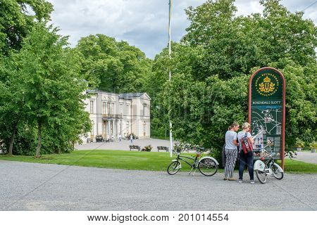 STOCKHOLM - JULY 5, 2017: Tourists with bikes at Rosendal palace in Stockholm. Rosendal palace located in the recreational area of Djurgarden is one of 11 Royal palaces in Sweden.
