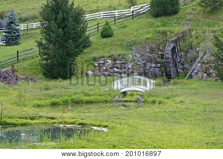 a decorative waterwheel, footbridge and pond make for pretty landscaping