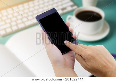 Man Hand Holding Smart Phone With White Blank Empty Screen On Blue Desk Table.