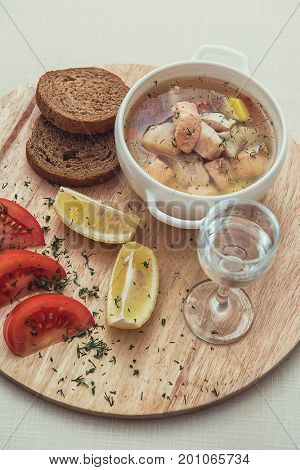 Russian traditional fish soup - ukha, served with bread lemon tomato and vodka