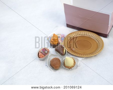 Chocolate candies open candies box on the table top covered with snow outdoor photo