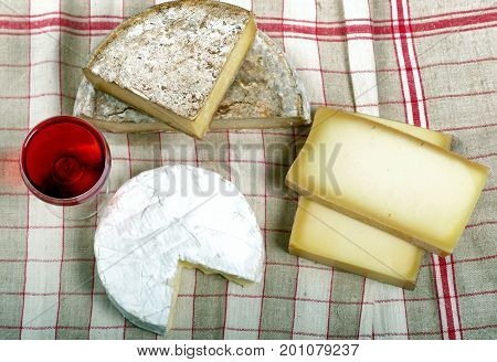 Different french cheeses with a glass of red wine