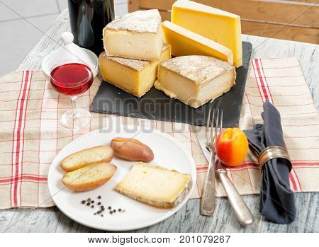 Different french cheeses with a glass of red wine