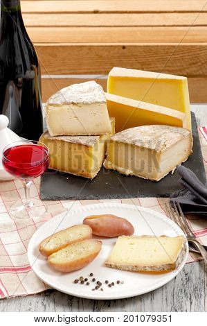 Different french cheeses with a glass of red wine