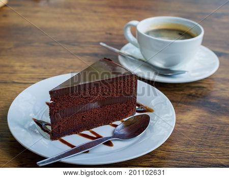 Delicious chocolate cake with spoon on white plate