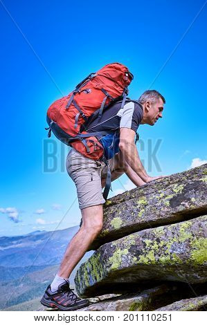 Hiking in the mountains with a backpack in the summer.