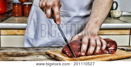 Butcher cutting pork meat on kitchen, man, coocking meat