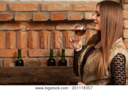 Woman Tasting Wine In Rural Cottage Interior