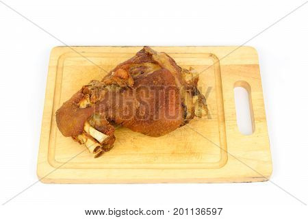 Schweinshaxe (german crispy pork knuckle) on a cutting board isolated white background.