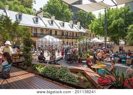 SYDNEY,NSW,AUSTRALIA-NOVEMBER 20,2016: People eating lunch at the Rocks Centre with musical group and local architecture by The Rocks Markets in Sydney, Australia.