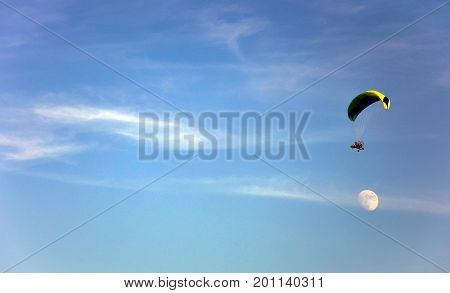 Paraglider in the sky flies over the moon