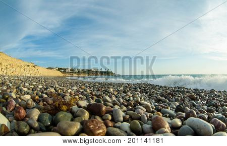 Beautiful pebble beach close-up in summer at sunset