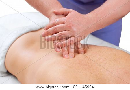 The masseur makes a massage on the back of the patient in the beauty salon. Medical care for the body.