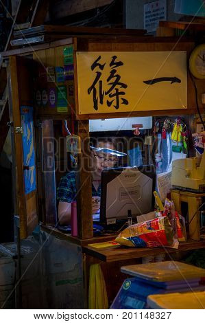 TOKYO, JAPAN JUNE 28 - 2017: Unidentified woman working in a coputer in the Fish Market Tsukiji wholesale in Tokyo Japan, Tsukiji Market is the biggest wholesale fish and seafood market in the world.