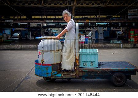 TOKYO, JAPAN JUNE 28 - 2017: Unidentified old man driving a cargo machine outside in Fish Tsukiji Market is the biggest wholesale fish and seafood market in the world, in Tokyo, Japan.