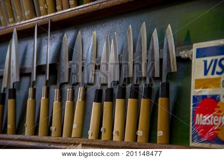 TOKYO, JAPAN JUNE 28 - 2017: Assorted knifes with a wooden handle in a Fish Tsukiji Market is the biggest wholesale fish and seafood market in the world, in Tokyo.