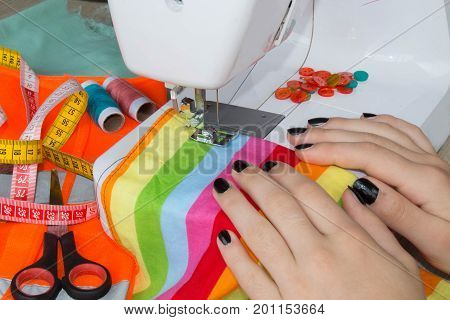 processes of sewing on the sewing machine sew women's hands sewing machine. Female tailor threading leather material on sewing machine