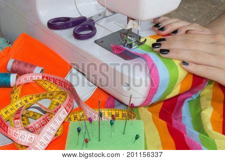 processes of sewing on the sewing machine sew women's hands sewing machine. Female tailor threading leather material on sewing machine