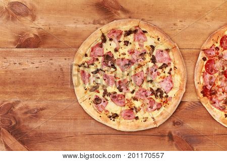 Pizza on wooden table top view. Fast food Delicious. Post blog social media. View from above with copy space. Banner template layout mockup top view on pizza. Pizza ready to eat.