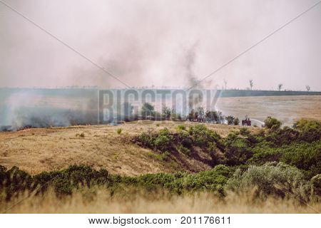 Natural summer fires among agricultural fields, toned