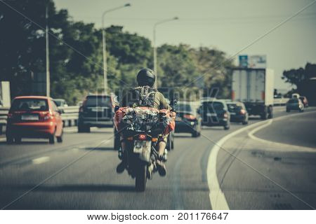 motorcycle traveler among traffic on the road, toned, selective focus