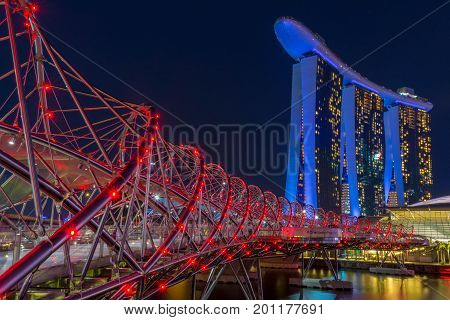 Singapore, Singapore - August 24, 2017: View at the Marina Bay in Singapore during the night with the iconic landmarks of The Helix Bridge.