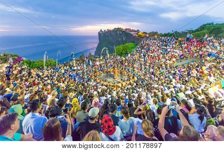 Bali, Indonesia - August 24, 2017: Tourists watch traditional Balinese Kecak Dance at Uluwatu Temple on Bali, Indonesia. 
Kecak Dance at Uluwatu Temple on Bali is very popular cultural show on Bali.