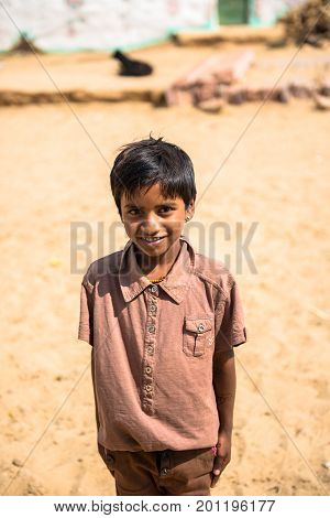 RAJASTHAN INDIA - MARCH 07 2016: Vertical picture of native indian boy smiling in Thar Desert located close to Jaisalmer the Golden City in India.