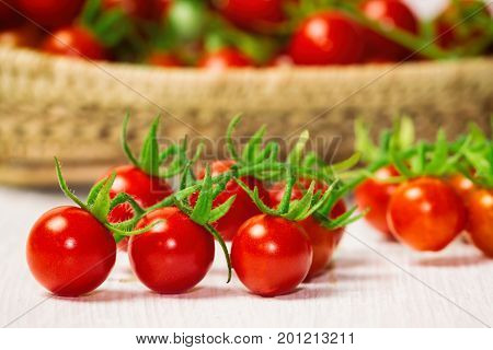 Fresh cherry tomato on wood basket. Close up lovely cherry tomato for background or wallpaper. Prepare fresh cherry tomato for home cooking look so delicious. Side view selective focus on foreground. Cherry tomato in fresh vegetable concept