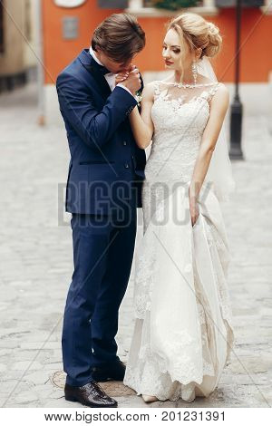 Romantic Groom Kising Hand Of Beautiful Happy Bride Outdoors, Newlywed Couple Portrait