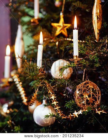 detail of burning candles on decorated Christmas tree