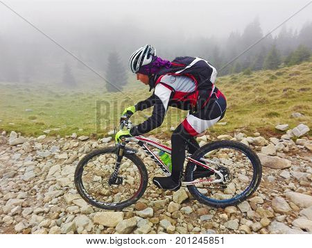Tarcu Romania - October 29 2016: Woman mountain biker descending a rocky trail in the mountains. Shot taken on October 29th 2016