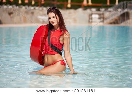 Beauty sexy lifeguard woman posing in swimming pool