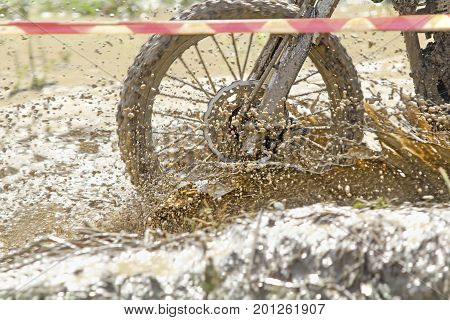 Motocross accelerating speed in mud trace .
