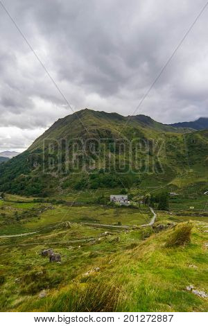 mountain lake and houses in Snowdonia National Park in North Wales of the United Kingdom. Snowdonia is a mountain range and a region in North of Wales.