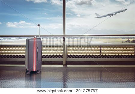 Suitcases in airport departure lounge airplane in background summer vacation concept traveler suitcases in airport terminal waiting area.