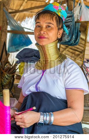 CHIANG MAI, THAILAND - July 10, 2017: Karen hill-tribe (Long Neck) woman weaving fabrics for a living at her house.