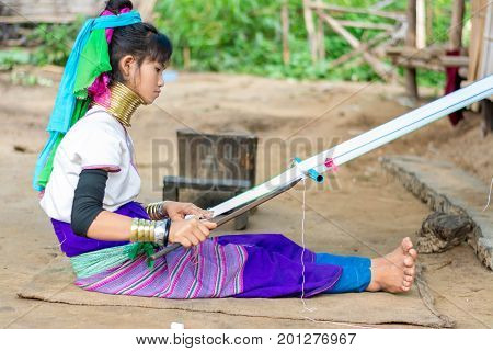 CHIANG MAI, THAILAND - July 10, 2017: Karen hill-tribe (Long Neck) woman weaving fabrics for a living at her house.