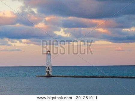 Pastel clouds over lake and light house