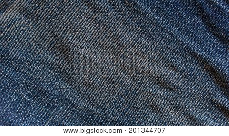 Blue fade denim jeans vintage western on dark indigo detail texture background