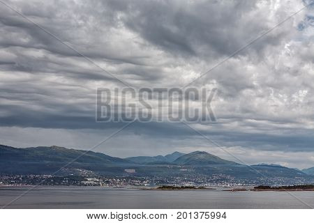 City and mountains along the Romsdalsfjorden near Andalsnes under a cloudy sky Norway