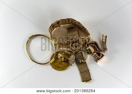 luxurious and expensive golden bracletes rings and coin. Luxury Jewellery.