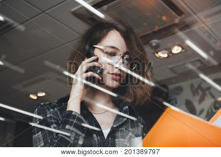 Close-up Photo Of Woman Talking On Phone With Director Of Development In Evening Office And Holding