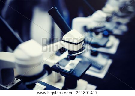 Blurred background of microscopes, toned photograph. Concept of medicine, education.