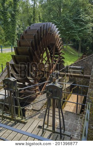 Old historically large rusted metal blade wheel of a water mill