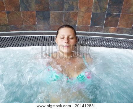 a relaxed woman doing hydromassage in a beauty spa