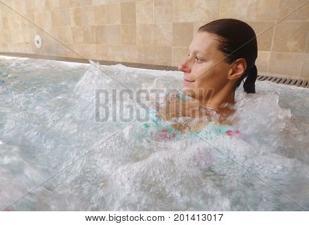 a relaxed woman doing hydromassage in a beauty spa