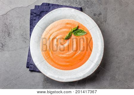 Traditional spanish andalusian tomato cream soup - salmorejo. Salmorejo or gazpacho cream soup on gray bowl, slate gray background.